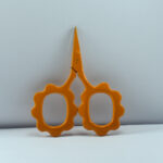 Mustard-colored sunflower-shaped embroidery scissors made of stainless steel, designed for precise cutting and decorative crafting.