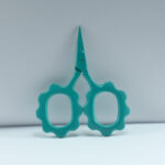 Sunflower-shaped embroidery scissors in teal green powder coating, 2.5'' forged stainless steel, ideal for embroidery, thread cutting, and detailed stitching work.