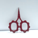 Sunflower-shaped embroidery scissors in burgundy powder coating, 2.5'' forged stainless steel, designed for detailed stitching and precise thread cutting.
