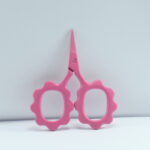 Punch pink sunflower-shaped embroidery scissors, 2.5" forged stainless steel with powder coating, ideal for precise thread cutting and fine needlework.