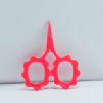 Sunflower-shaped embroidery scissors in bright pink powder coating, 2.5'' forged stainless steel, ideal for thread trimming and precision stitching.