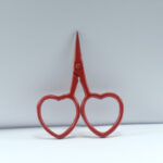 2.5-inch red heart-shaped embroidery scissors made from stainless steel, perfect for thread cutting and small needlework tasks.