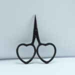 2.5-inch black heart-shaped embroidery scissors with forged stainless steel blades, ideal for precise thread cutting and needlework.
